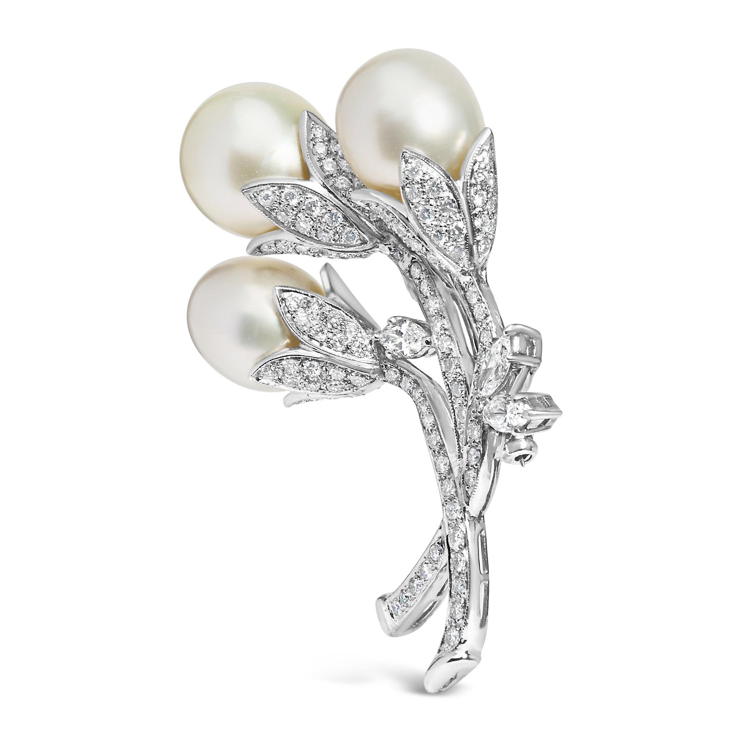 White metal brooch shaped like a flower bouquet with three large white pearls and multiple small round white gemstones in a pave setting, shown in a side angle view.