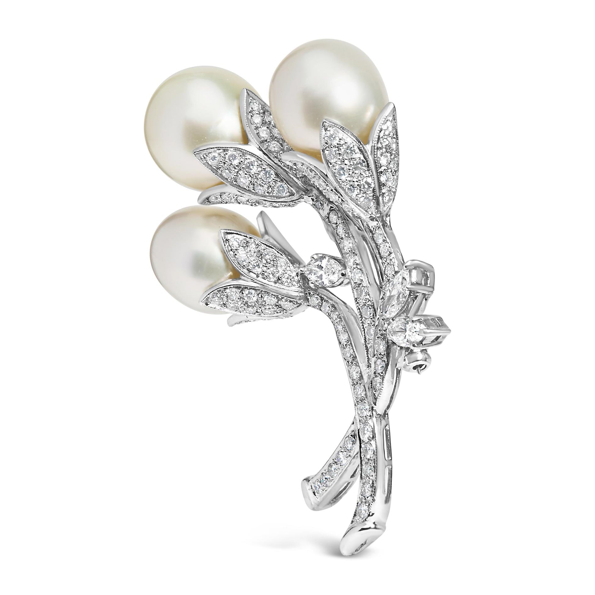 White metal brooch shaped like a flower bouquet with three large white pearls and multiple small round white gemstones in a pave setting, shown in a side angle view.