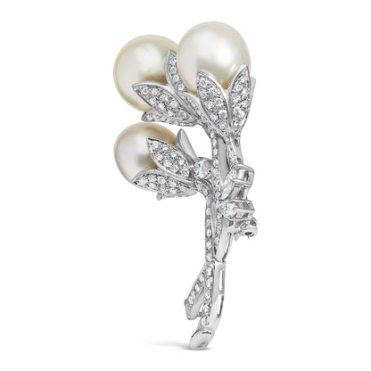 White metal brooch shaped like a floral bouquet with three round white gemstones and multiple small white gemstones in pave setting, shown from a slightly angled front view.