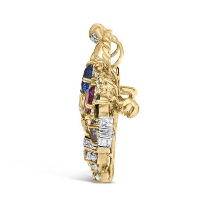 Side view of a yellow metal brooch with channel-set white baguette gemstones, prong-set white round gemstones, and two prong-set colored oval and pear-shaped gemstones in blue and purple.