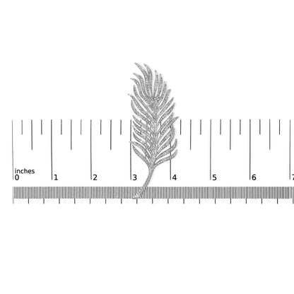 White metal brooch shaped like a feather with pave set round white gemstones, shown from top down on a ruler for size reference.