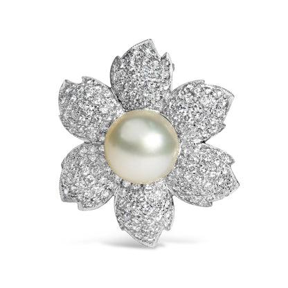 Brooch in flower shape with white metal petals pave set with round white gemstones and a central large white gemstone, front-facing angle.