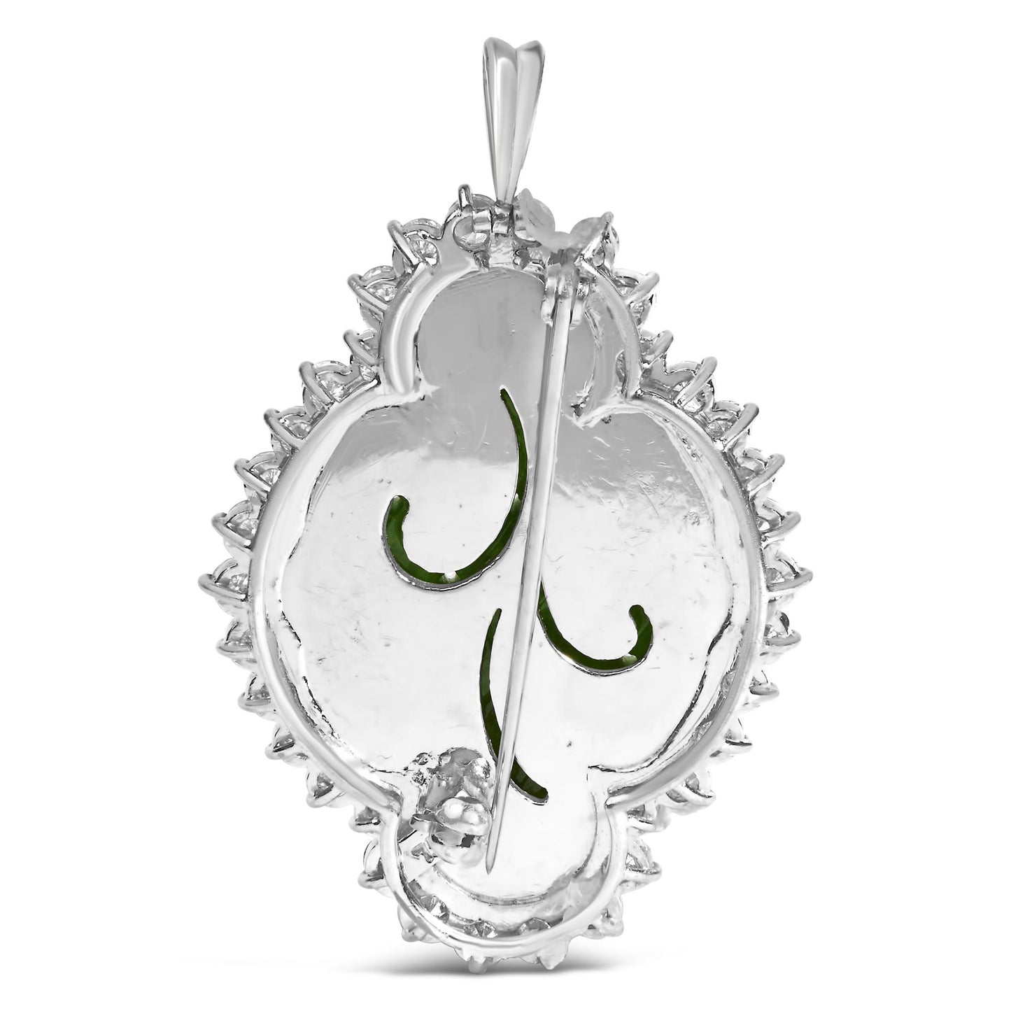 Back view of a white metal brooch with a pin clasp and green gemstone details, shown in a close-up shot.