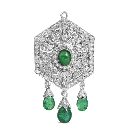 Front view of a white metal hexagonal brooch featuring a central oval green gemstone surrounded by round white gemstones in pave setting, with intricate scrollwork and three dangling teardrop-shaped green gemstones below.