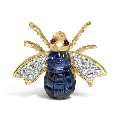 Front angle view of a yellow metal bee-shaped brooch with red gemstones as eyes, blue gemstones on the body, and white gemstones on the wings.
