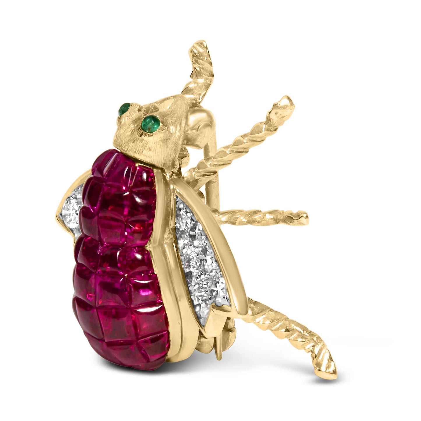 Yellow metal bug-shaped brooch with red gemstones on the back and white gemstones on the wings, green gemstones on the head, shown at an angled side view.
