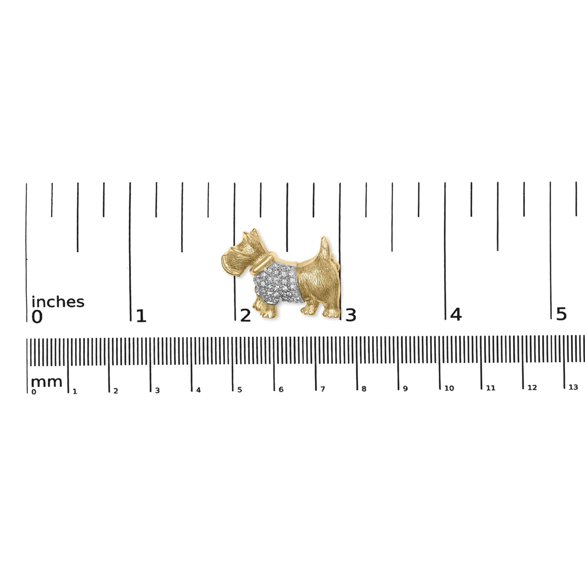 Yellow metal dog-shaped brooch with pave-set round white gemstones on the body, shown flat on a ruler for size reference.