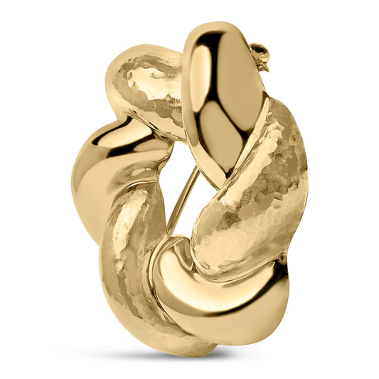 Close-up front angle of a yellow metal twisted and textured circular brooch.