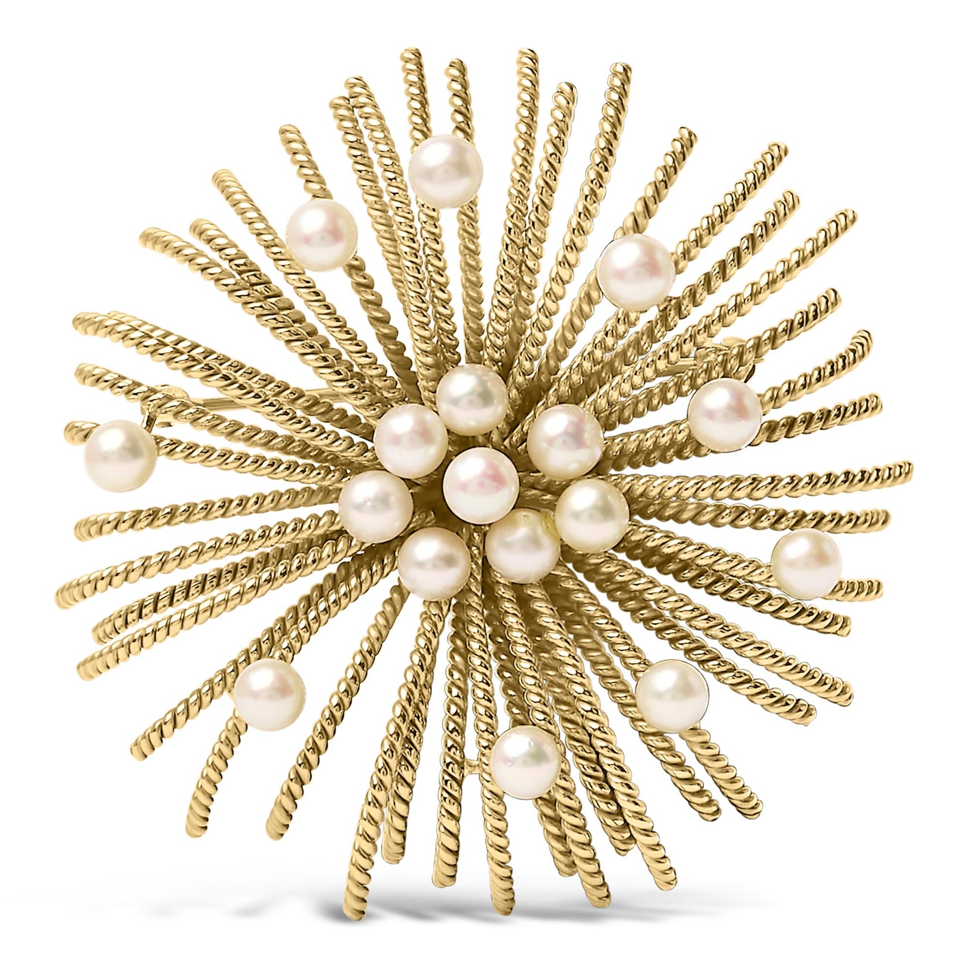 Top-down close-up of a yellow metal brooch with twisted rods radiating outward, adorned with multiple white pearls.