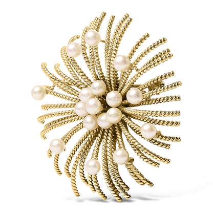 Close-up front angle of a yellow metal brooch with twisted wires radiating outward, adorned with multiple white round gemstones.