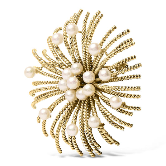Close-up front angle of a yellow metal brooch with twisted wires radiating outward, adorned with multiple white round gemstones.