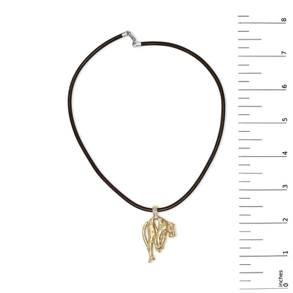 Top-down view of a yellow metal necklace with an animal-shaped pendant featuring various white gemstones in bezel and channel settings, displayed on a ruler for size reference.