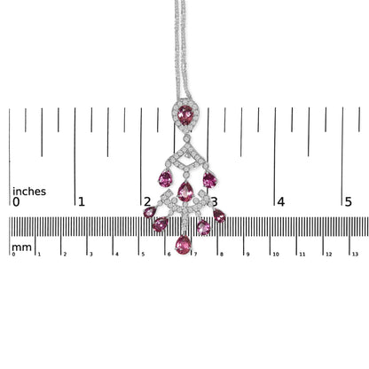 White metal necklace with pink pear-shaped gemstones and round white gemstones in prong settings, shown flat against a ruler for size reference, photographed from above.