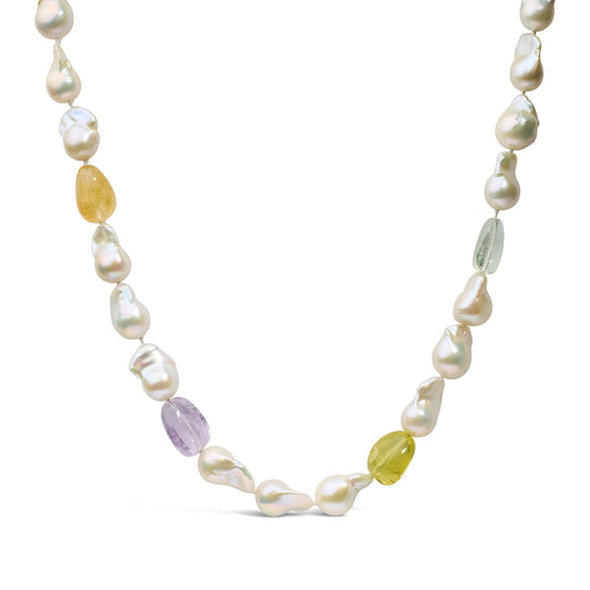 Close-up front view of a yellow metal necklace featuring irregular white pearls and three yellow gemstones with drilled settings.