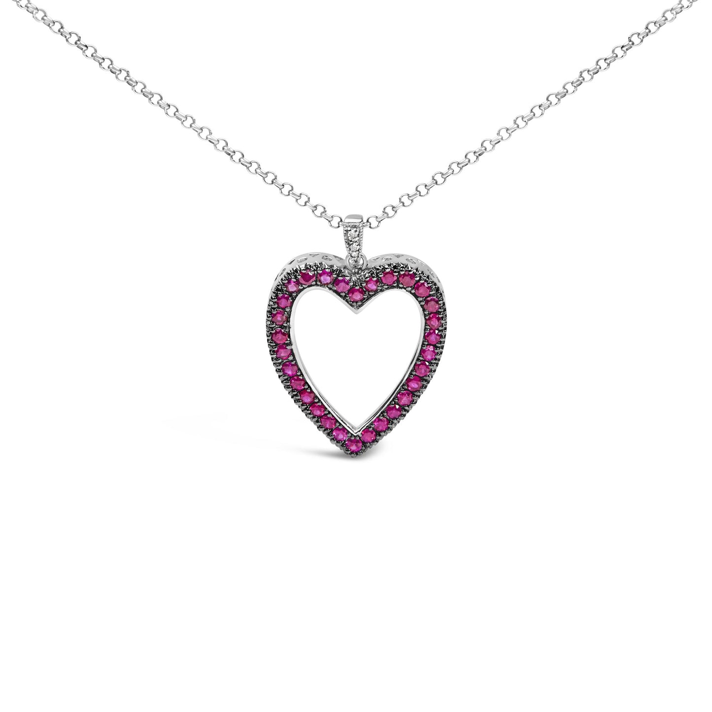Front-facing shot of a white metal heart-shaped necklace pendant adorned with round red gemstones in shared prong setting and a few round white gemstones in pave setting on the bail.
