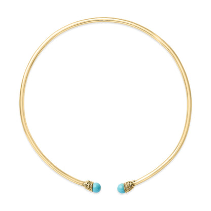 Top-down angled view of an open circular yellow metal necklace with round blue gemstone accents at each end.