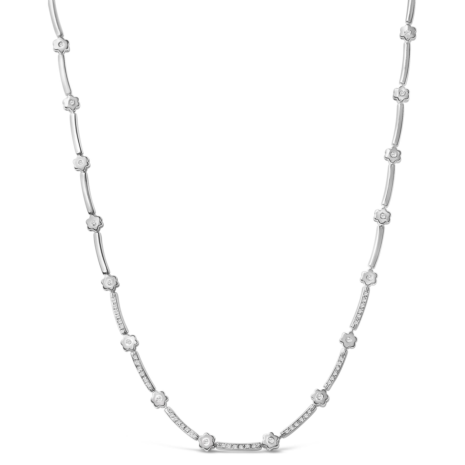 Close-up front view of a white necklace featuring a pattern of small flower shapes each set with a white round gemstone and curved bars, some adorned with a row of small white round gemstones.