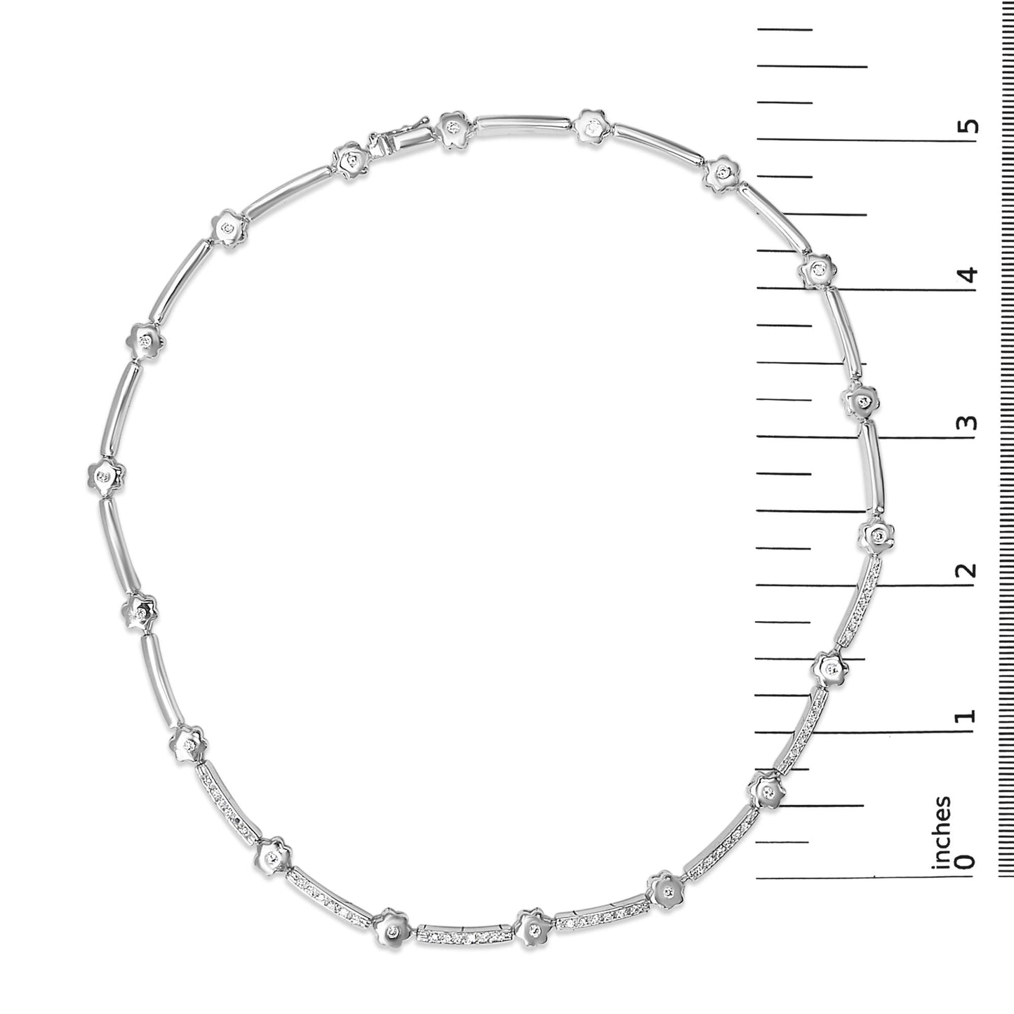 Top-down view of a white metal necklace displayed on a ruler scale, featuring alternating small floral-shaped settings with white gemstones and slender bar segments, some adorned with multiple white gemstones in bezel settings.