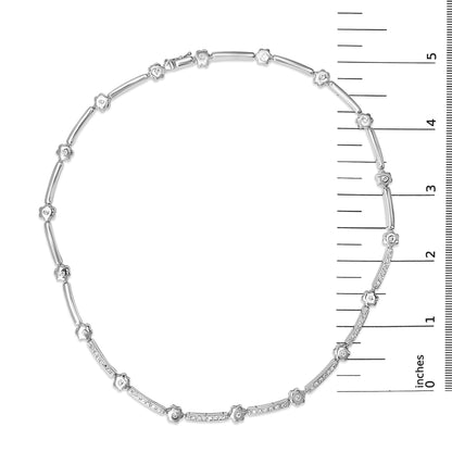 Top-down view of a white metal necklace displayed on a ruler scale, featuring alternating small floral-shaped settings with white gemstones and slender bar segments, some adorned with multiple white gemstones in bezel settings.
