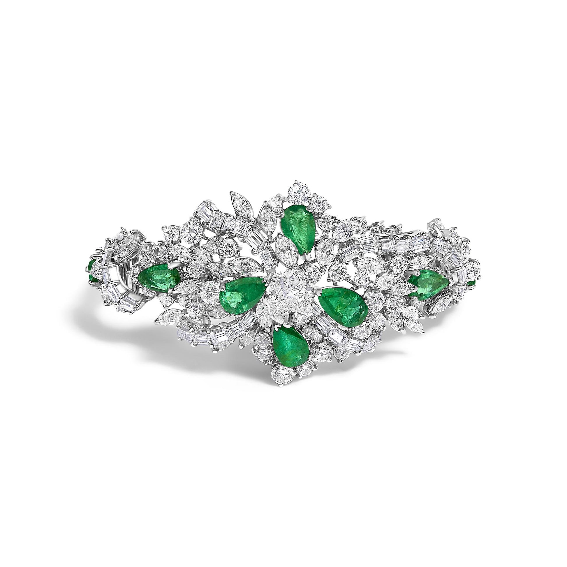 Top-down angle of a white metal bracelet set with pear-shaped green gemstones and a variety of round, baguette, and marquise-shaped white gemstones arranged in an intricate floral-inspired design.