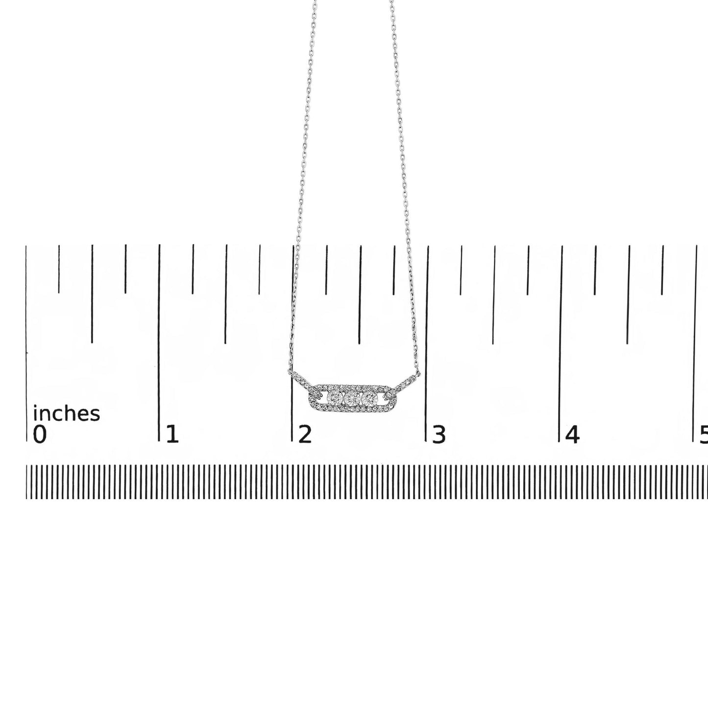 White metal necklace with a horizontal bar pendant featuring three round white gemstones in miracle setting surrounded by smaller round white gemstones in prong setting, shown on a ruler scale from a front angle.