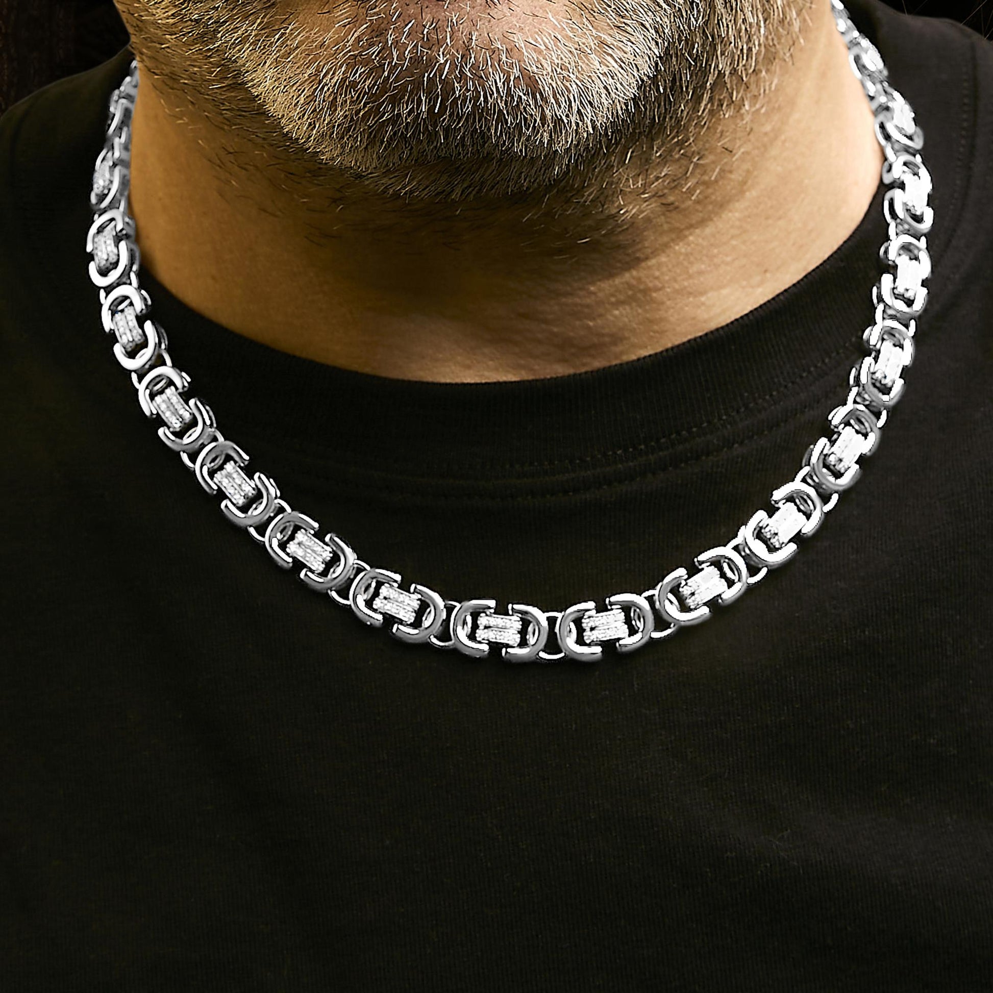 White metal necklace with linked rectangular segments featuring round white gemstones in prong settings, shown worn by a model from a front close-up angle.