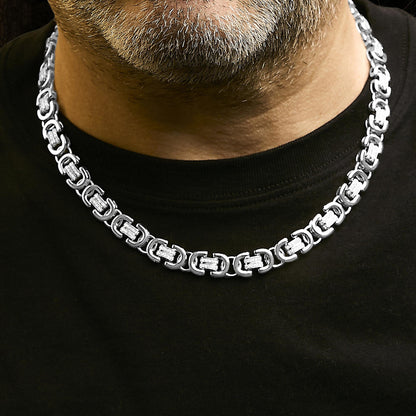 White metal necklace with linked rectangular segments featuring round white gemstones in prong settings, shown worn by a model from a front close-up angle.