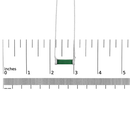 White necklace with a horizontal green baguette-shaped gemstone in the center, flanked by two vertical sections with small round white gemstones in pave setting, shown from the front on a scale.