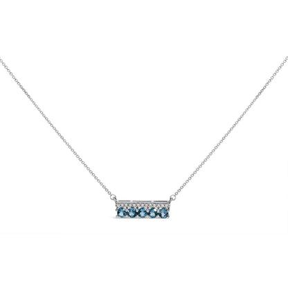 Front angle view of a white necklace with a rectangular pendant. The pendant features a row of small white gemstones in a pave setting on the top half and five round blue gemstones in a prong setting on the bottom half. The necklace is displayed on a white background.