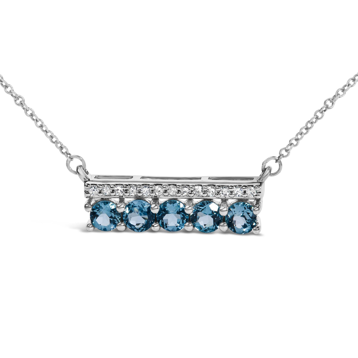 Close-up front angle of a white metal necklace pendant with a horizontal rectangular bar set with pavé white round gemstones on the top edge and prong-set round blue gemstones along the bottom edge, shown on a white background.