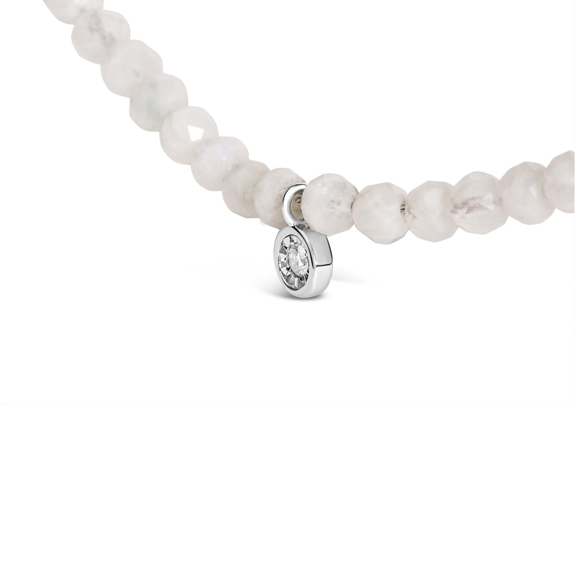 Close-up front angle of a white metal necklace featuring round white gemstones with a single round white gemstone pendant in a miracle setting.