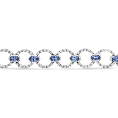 Bracelet shown from the front angle featuring alternating circular links set with small white gemstones and oval blue gemstones in bezel settings.