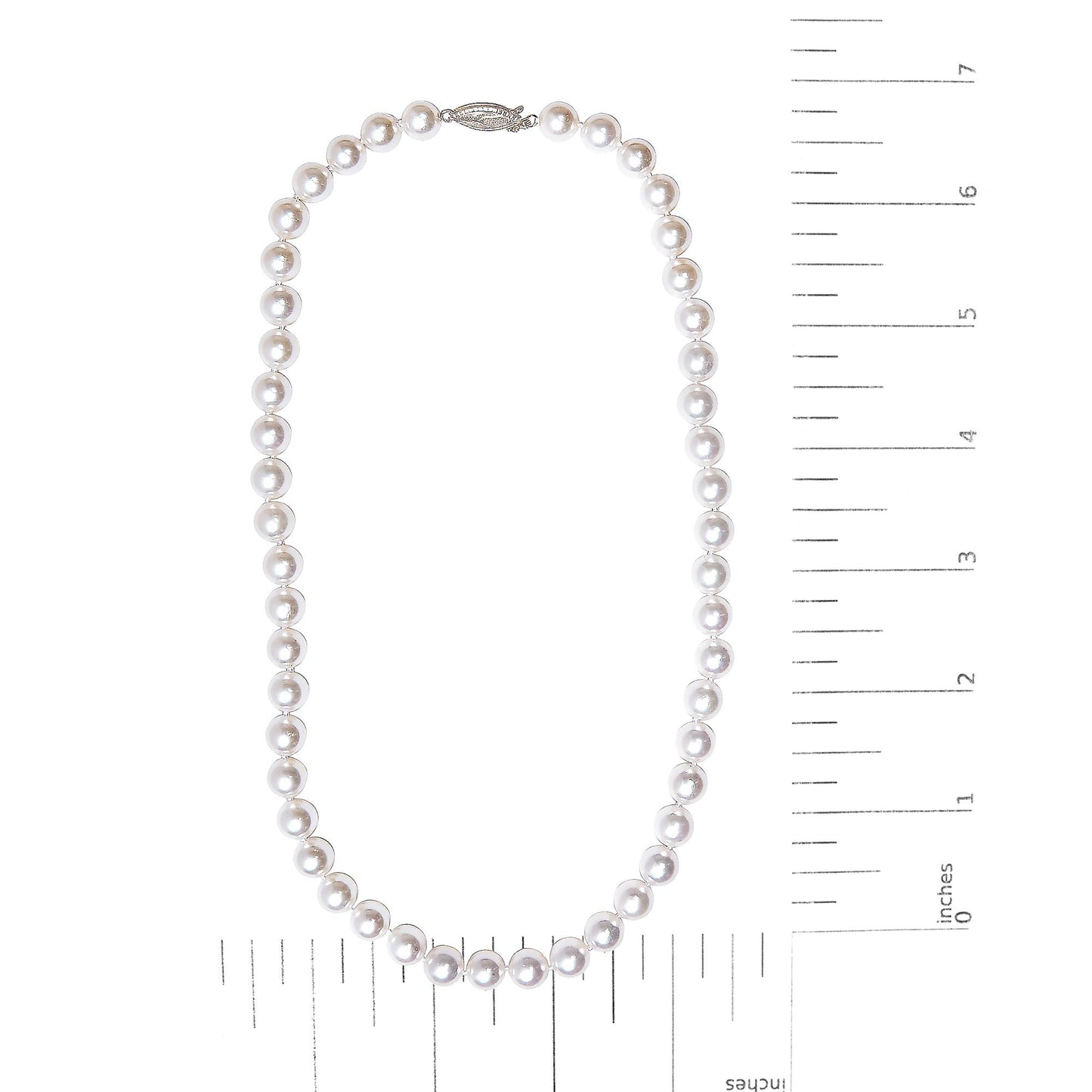 Top-down view of a white metal pearl necklace displayed flat on a measuring scale.