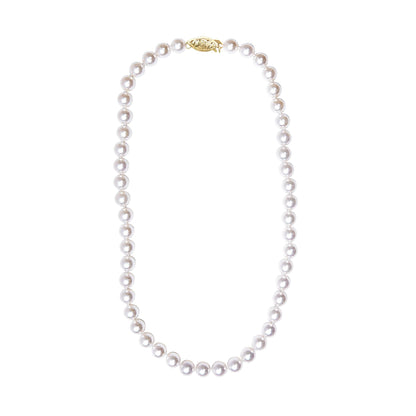 Yellow metal clasp with a string of round white pearls necklace, shown flat from a top-down angle.