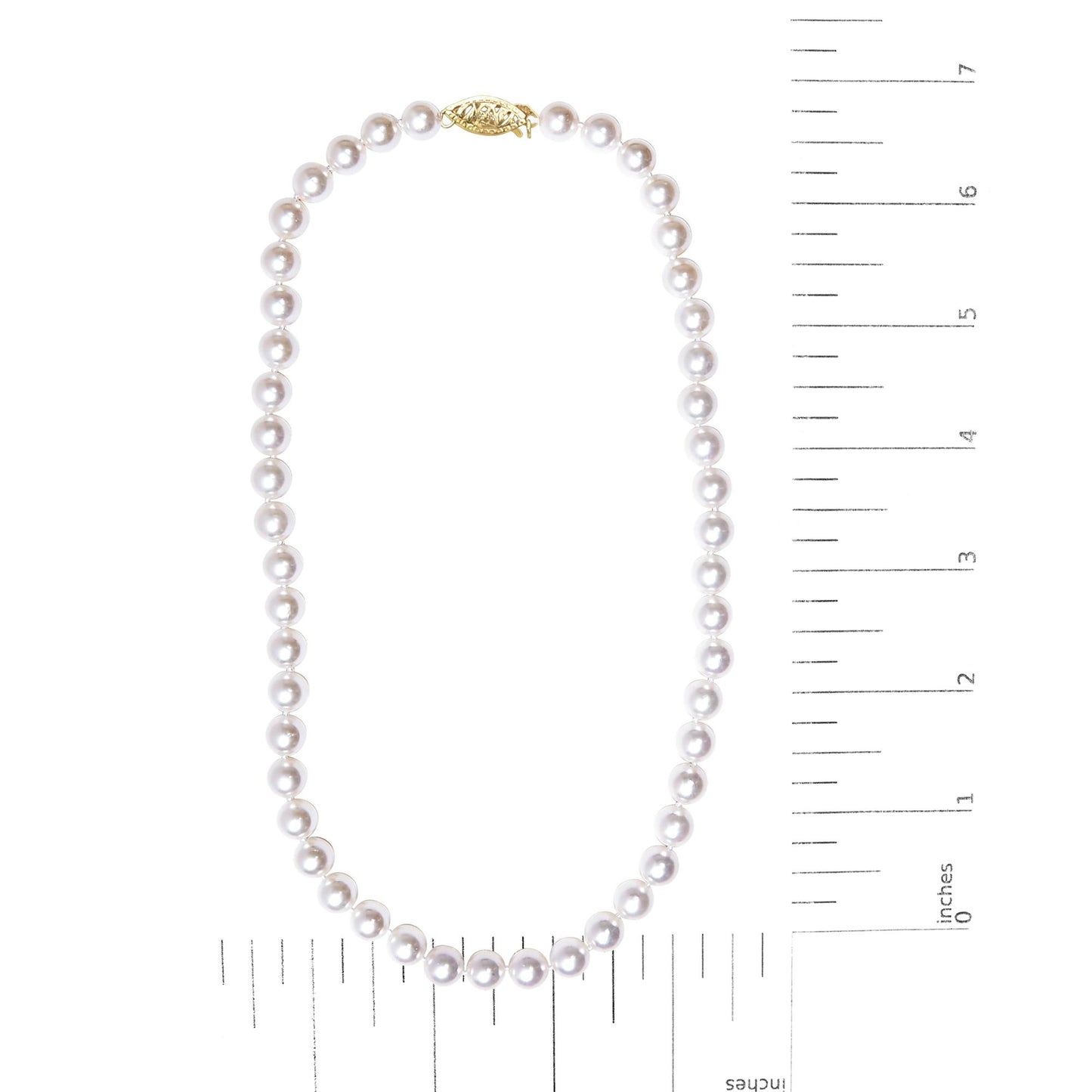 Top-down view of a necklace shown on a scale, featuring round white beads with a yellow metal clasp.