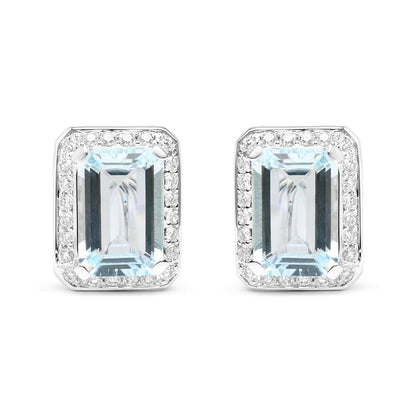 Front-facing shot of white metal earrings featuring large rectangular blue gemstones surrounded by a border of small round white gemstones.