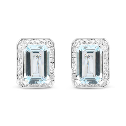 Front-facing shot of white metal earrings featuring large rectangular blue gemstones surrounded by a border of small round white gemstones.