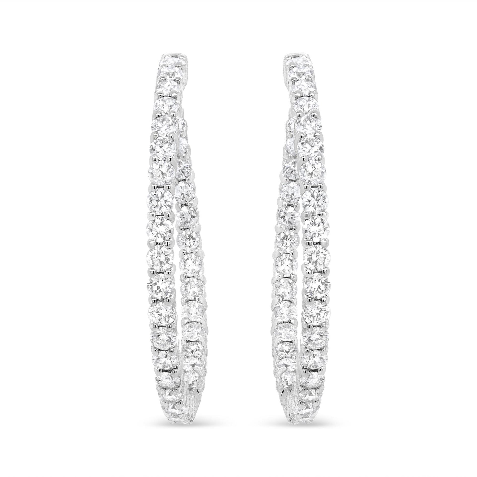 Pair of white metal hoop earrings with two rows of prong-set round white gemstones, shown from the front angle on a white background.