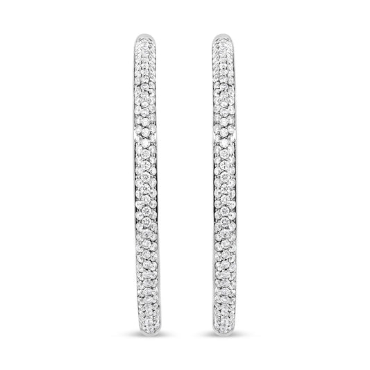 Pair of white metal hoop earrings encrusted with small round white gemstones in prong setting, shown from a front angle.