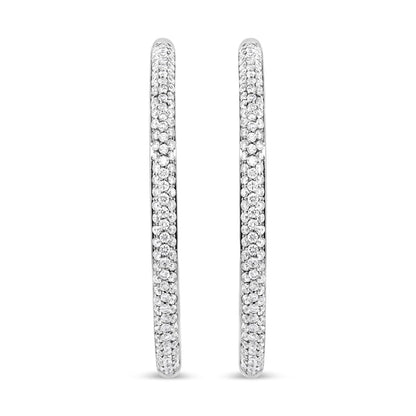 Pair of white metal hoop earrings encrusted with small round white gemstones in prong setting, shown from a front angle.