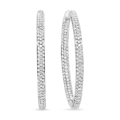 Close-up front and side view of white metal hoop earrings with round white gemstones in prong settings covering the outer surface.