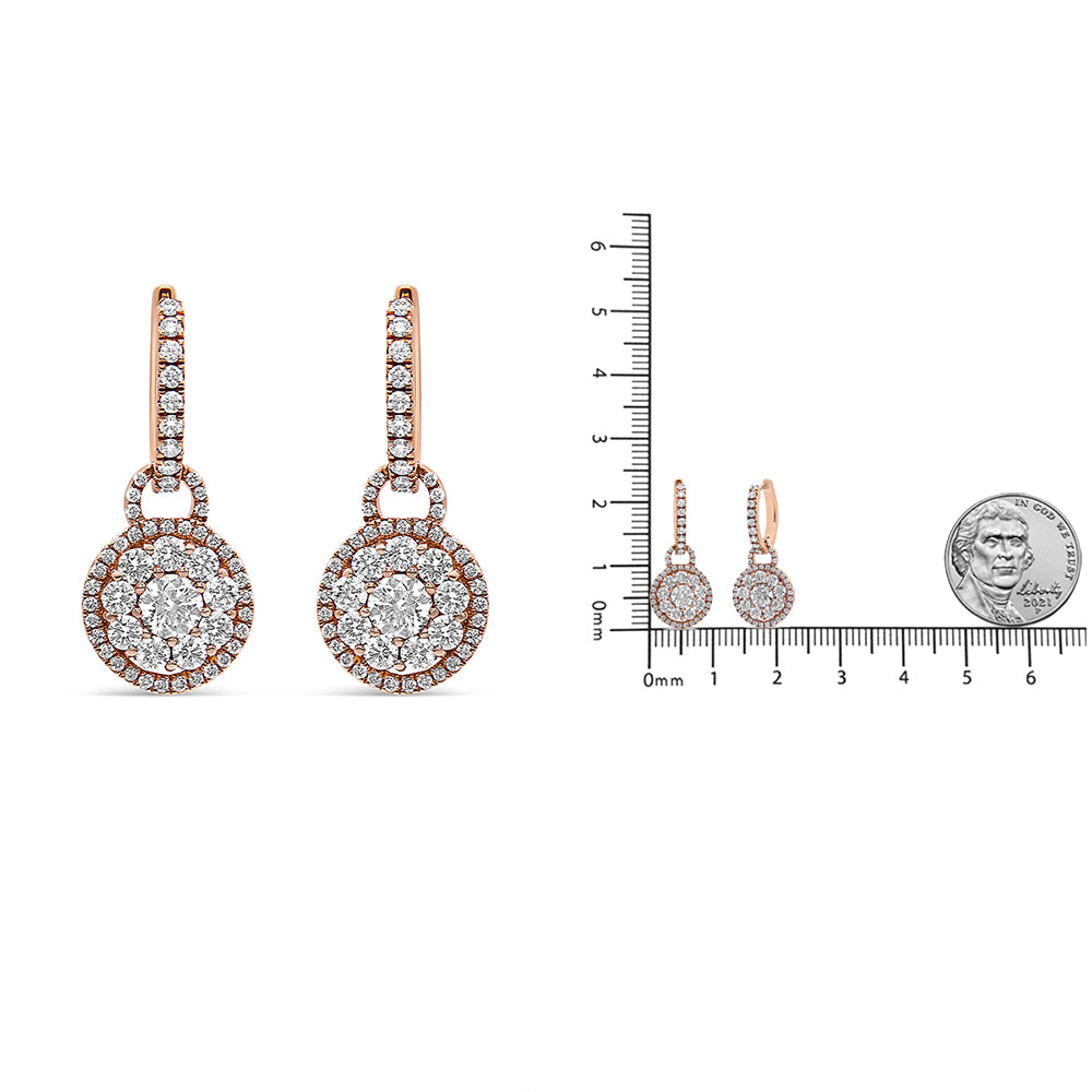 Pair of rose metal drop earrings with round white gemstones in prong settings, shown front-facing on the left and side-facing on the right, displayed next to a ruler and coin for size reference.