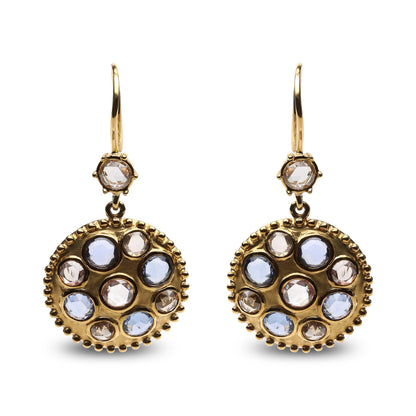 Front-facing shot of yellow metal earrings with round bezel settings featuring blue and brown gemstones and white gemstones in a circular pattern.