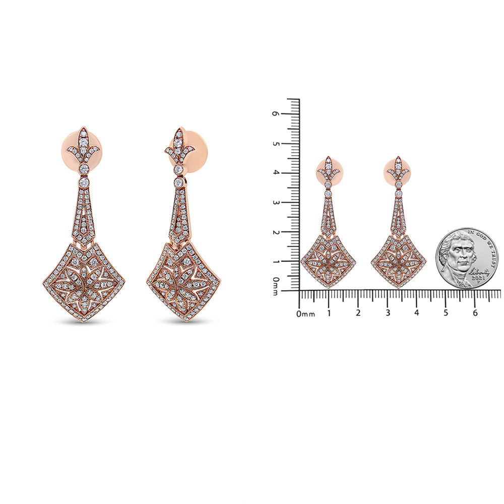 Pair of rose-colored metal drop earrings with intricate filigree design and multiple white gemstones, shown in a front angle on the left and alongside a ruler and a coin for size reference on the right.