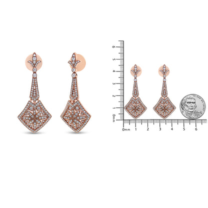 Pair of rose-colored metal drop earrings with intricate filigree design and multiple white gemstones, shown in a front angle on the left and alongside a ruler and a coin for size reference on the right.
