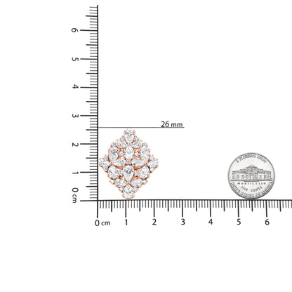 Close-up angled shot of a rose-colored metal earring with multiple pear-shaped and round white gemstones in prong settings, displayed on a ruler and next to a coin for size reference.