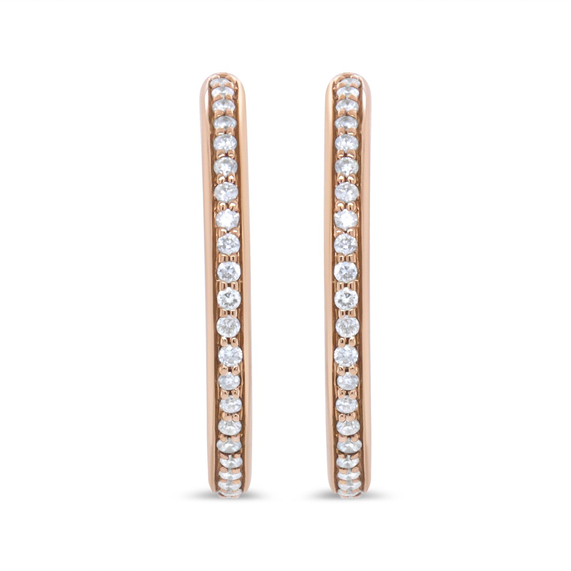 Front view of rose-colored metal hoop earrings with round white gemstones in prong settings along the outer edges.