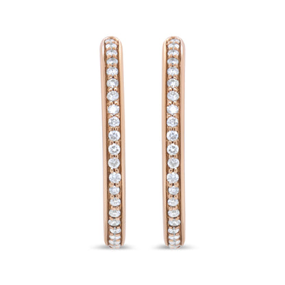 Front view of rose-colored metal hoop earrings with round white gemstones in prong settings along the outer edges.