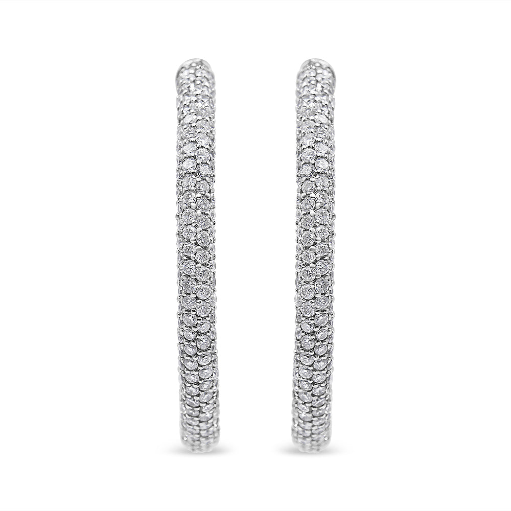 Front-facing shot of a pair of white metal hoop earrings set with multiple rows of round white gemstones in a pave setting.