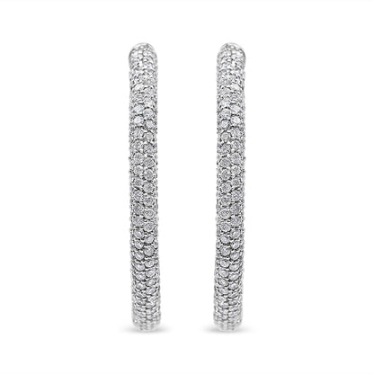 Front-facing shot of a pair of white metal hoop earrings set with multiple rows of round white gemstones in a pave setting.